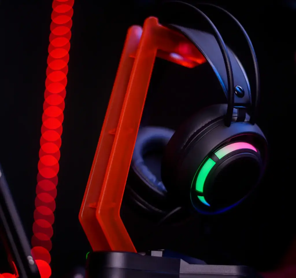 De zwarte gamingheadset ligt op een oranje standaard.